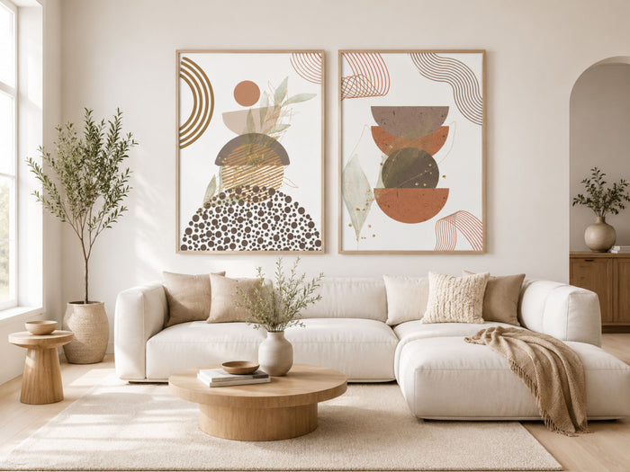 Abstract botanical wall art set of 2 in oak frames, terracotta, sage and gold prints above a sofa in a bright Scandinavian living room by VYLOIRE.