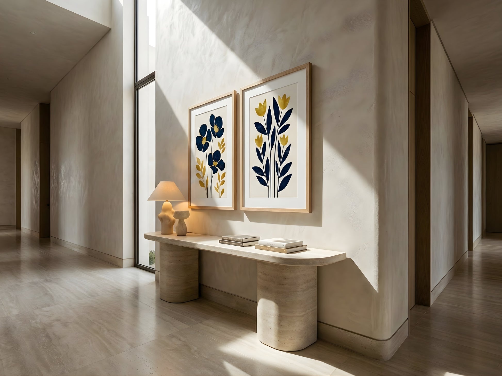 Framed navy and mustard botanical wall art set of 2 above a travertine console in a luxury entryway hallway by VYLOIRE